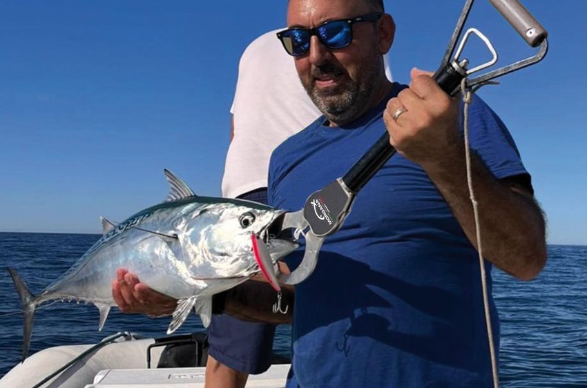 Pescatore solleva una palamita utilizzando il Boga Crocodile Grip Morgana durante una battuta di pesca in mare